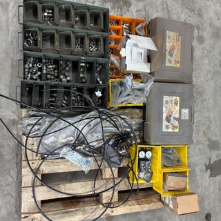 Afbeelding van pallet met moeren en 2 grijze koffers