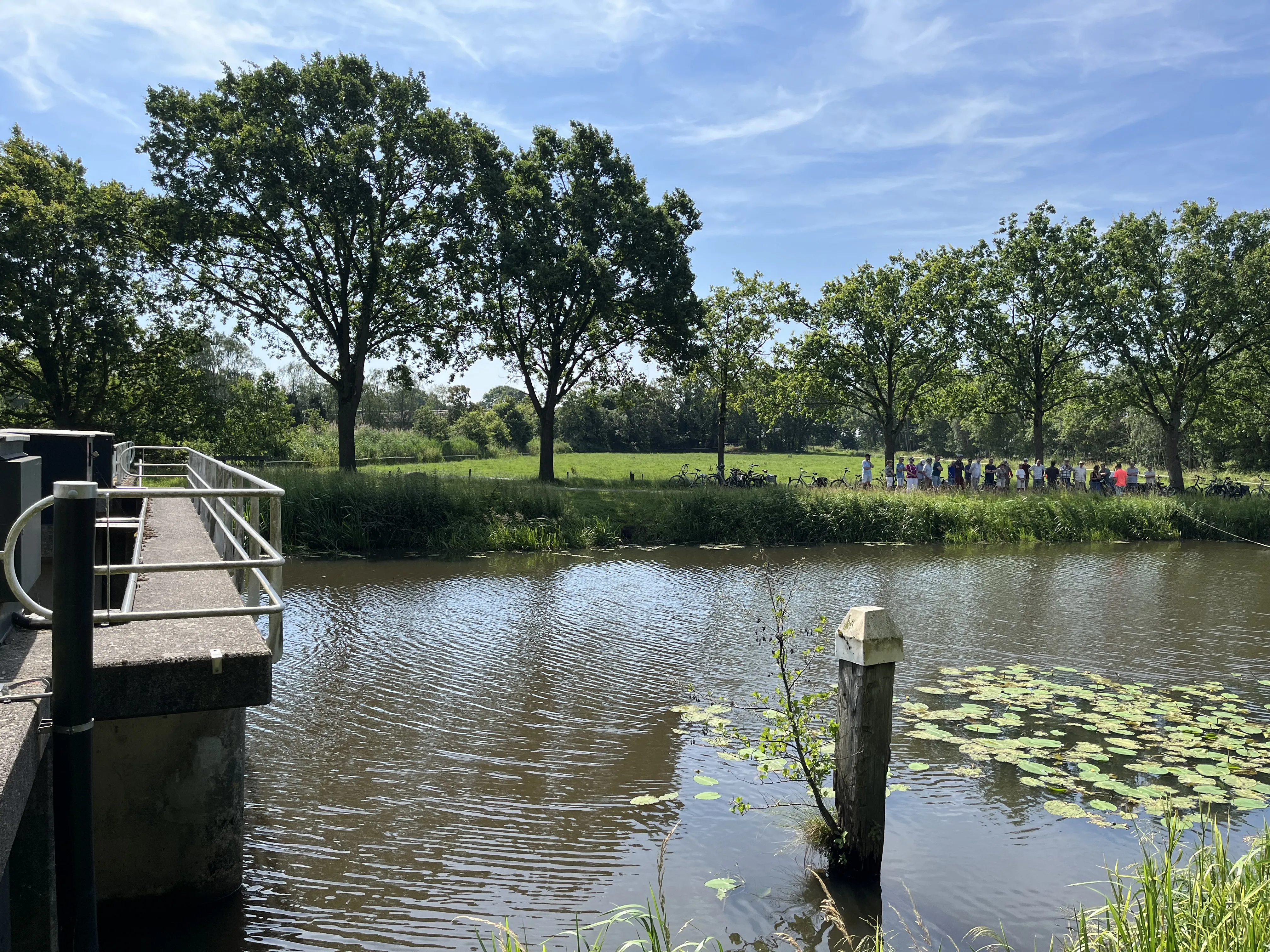 Deelnemers aan de fietstocht op 20 juni staan bij de stuw Blauwe Kamer