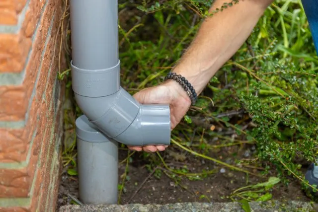 Stap 3 - Schuif de bocht over het bovenste deel van de regenpijp