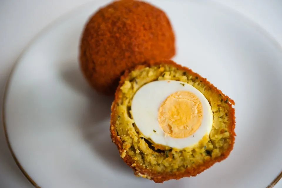 The eierbal is a well-known deep-fried snack, especially popular in Groningen and the northeastern Netherlands. It consists of a hard-boiled egg coated in a thick, often curry-flavored ragout, breaded, and deep-fried until golden brown and crispy.