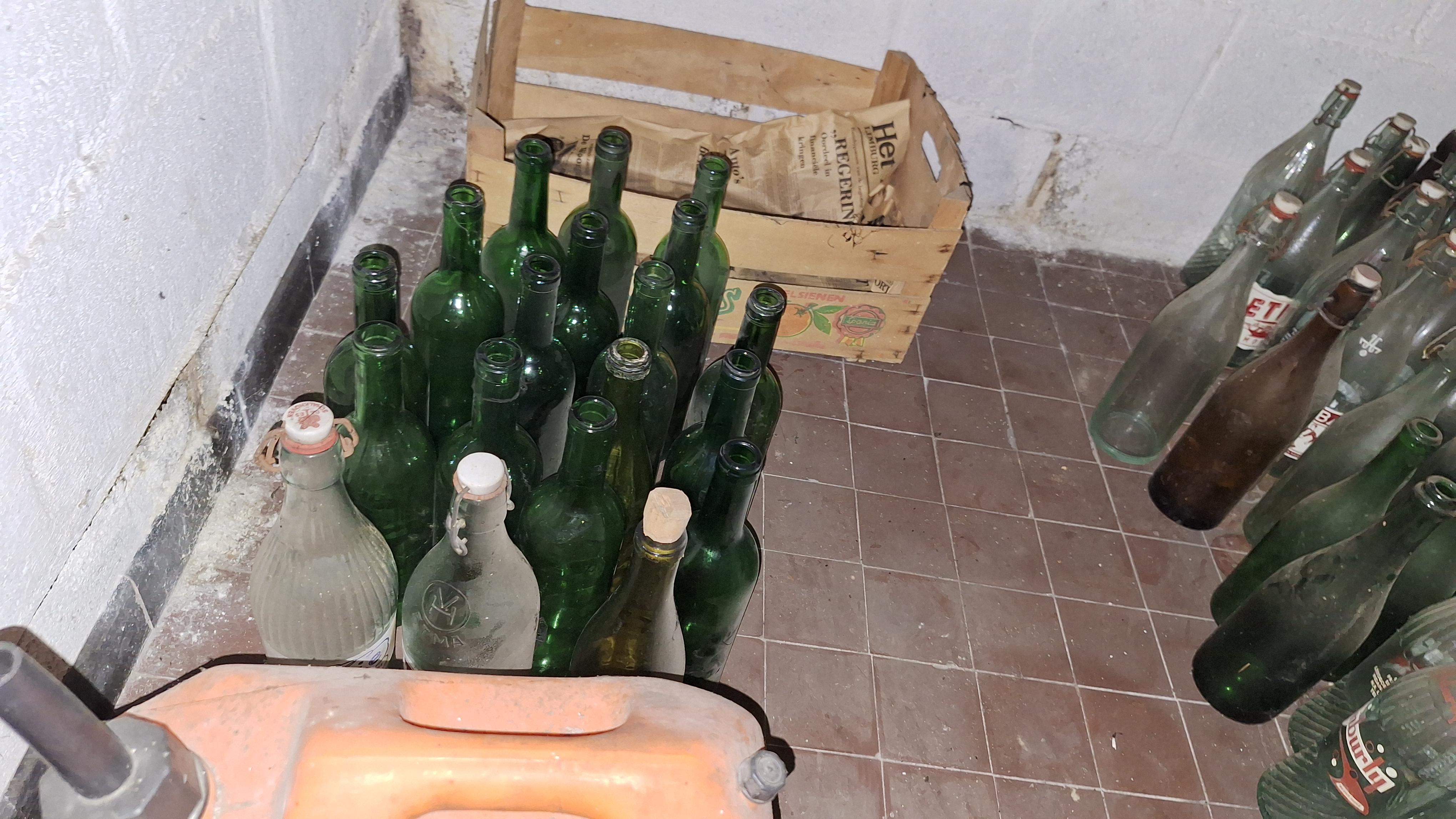 Grote partij lege glazen flessen verdeeld over de vloer en een houten krat – foto 4 – kavel bij Goeiendeal, Houthalen-Helchteren