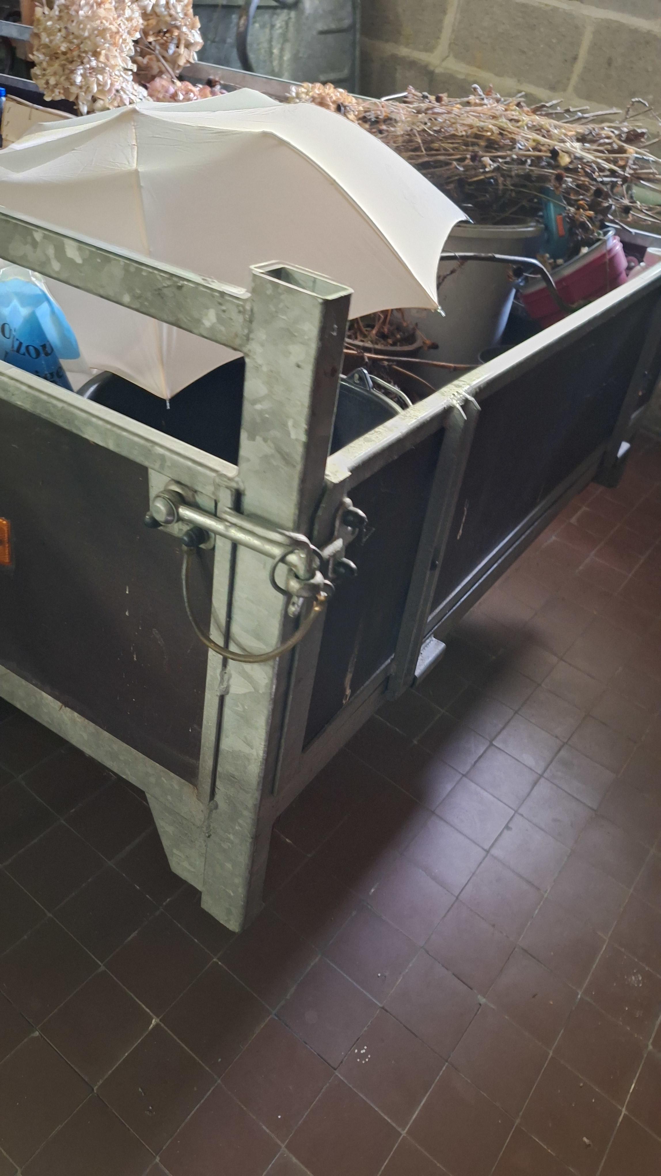 Enkelassige aanhangwagen met metalen zijborden gevuld met diverse spullen waaronder een parasol en snoeiafval pas op 1 band is plat – foto 2 – kavel bij Goeiendeal, Houthalen-Helch