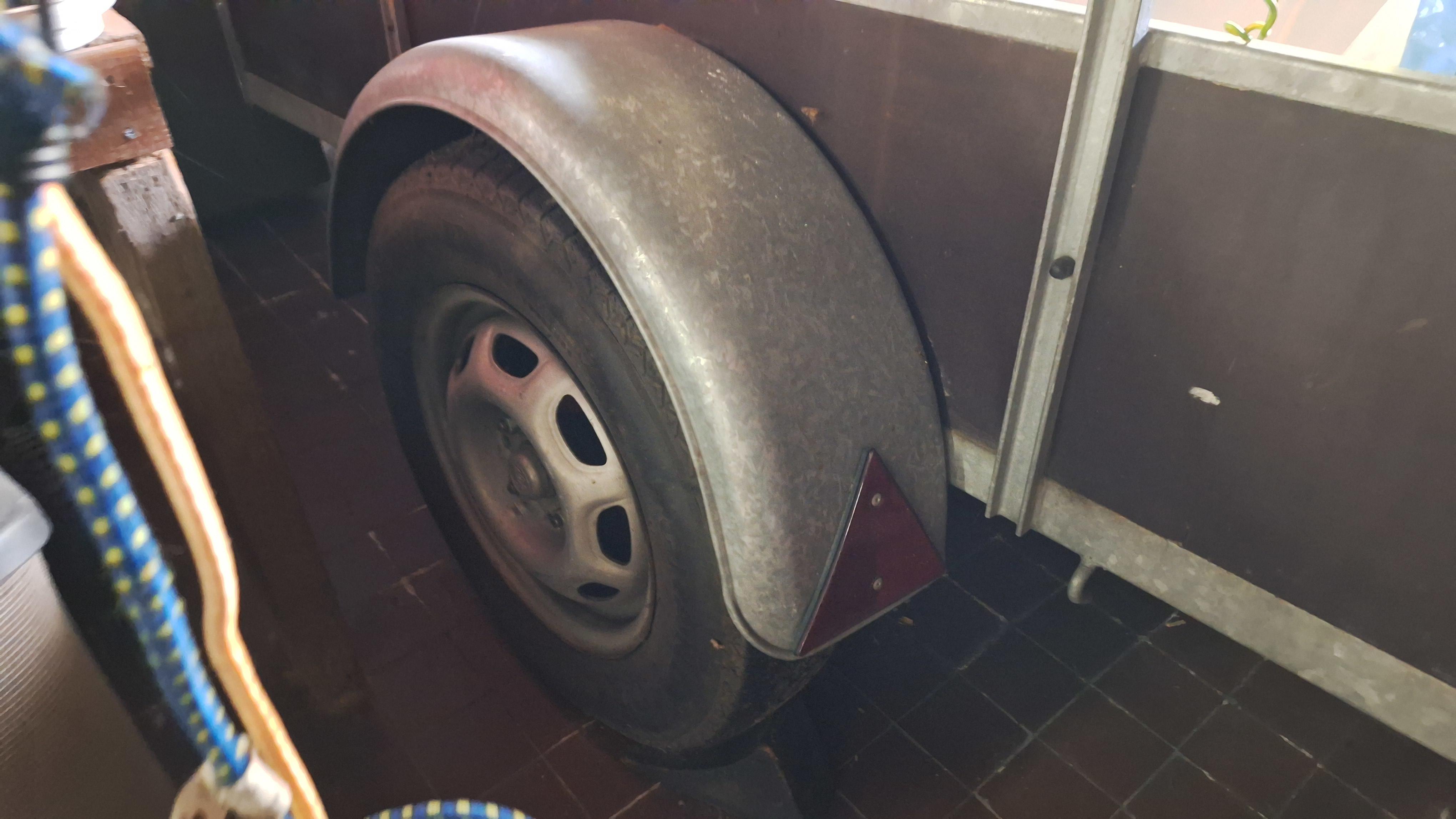 Enkelassige aanhangwagen met metalen zijborden gevuld met diverse spullen waaronder een parasol en snoeiafval pas op 1 band is plat – foto 3 – kavel bij Goeiendeal, Houthalen-Helch