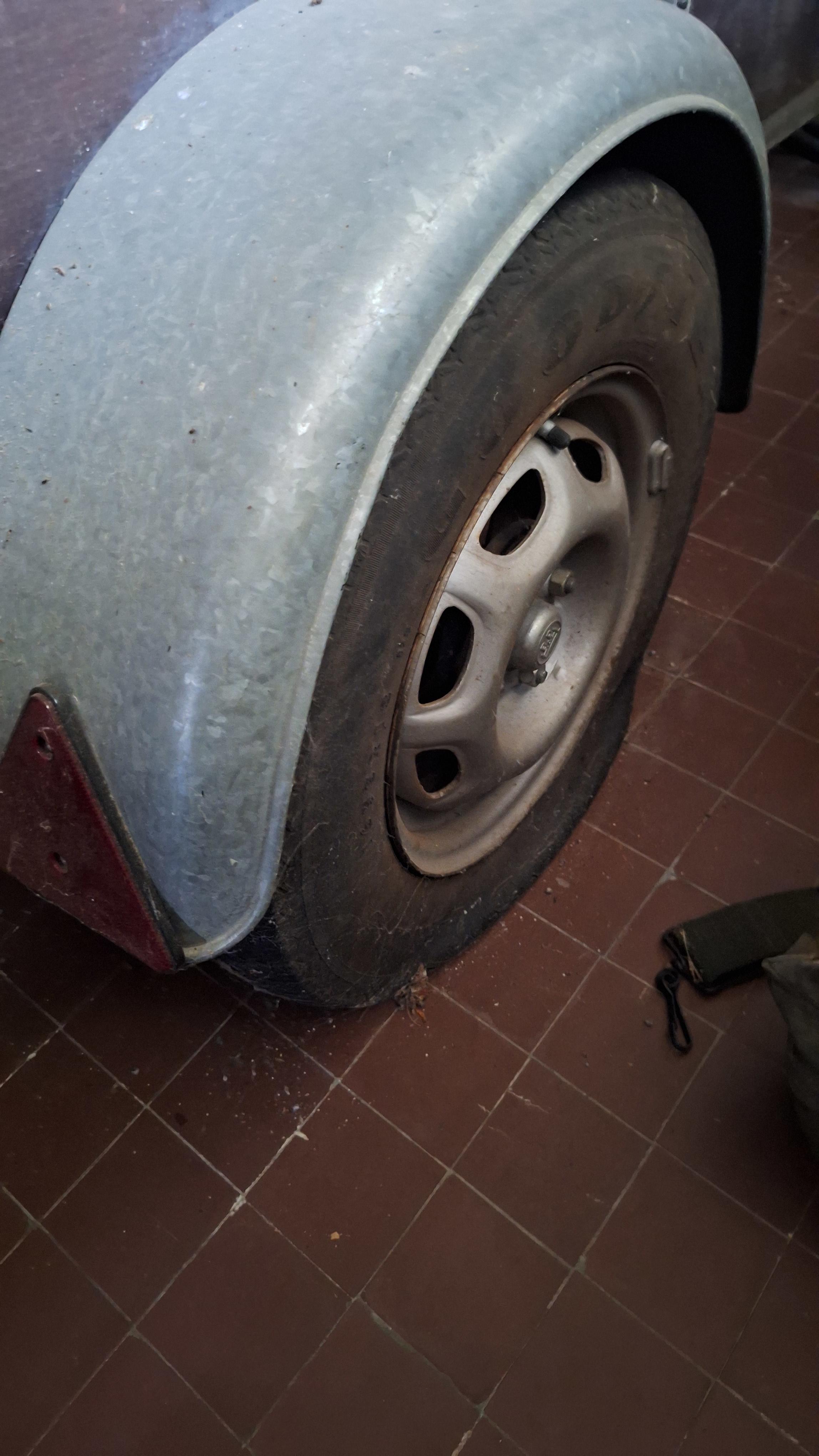 Enkelassige aanhangwagen met metalen zijborden gevuld met diverse spullen waaronder een parasol en snoeiafval pas op 1 band is plat – foto 5 – kavel bij Goeiendeal, Houthalen-Helch