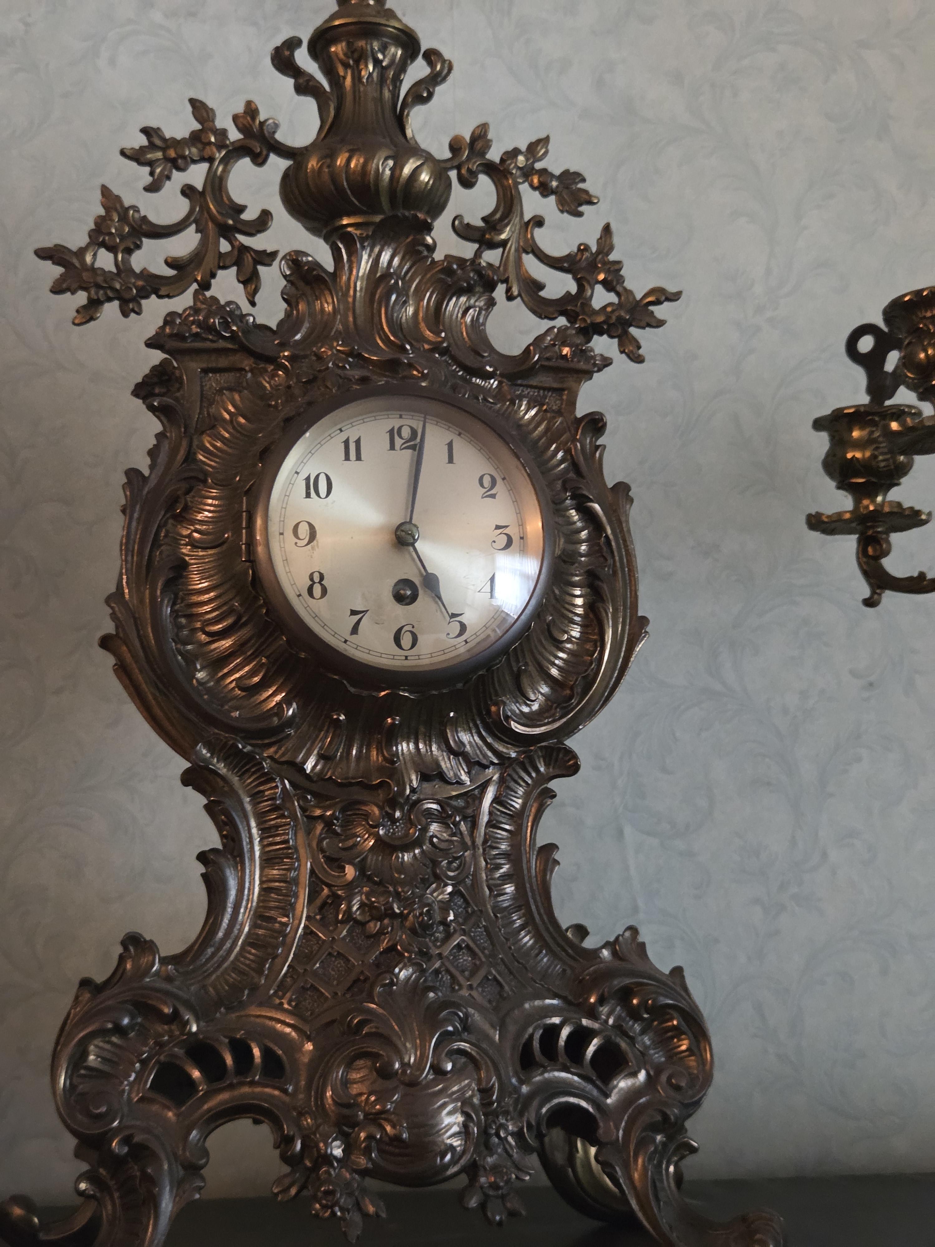 Driedelig schouwgarnituur bestaande uit een rijkelijk gedecoreerde tafelklok met Romeinse cijfers en twee bijbehorende 5-armige kandelaren lot 57 – foto 2 – kavel bij Goeiendeal, J