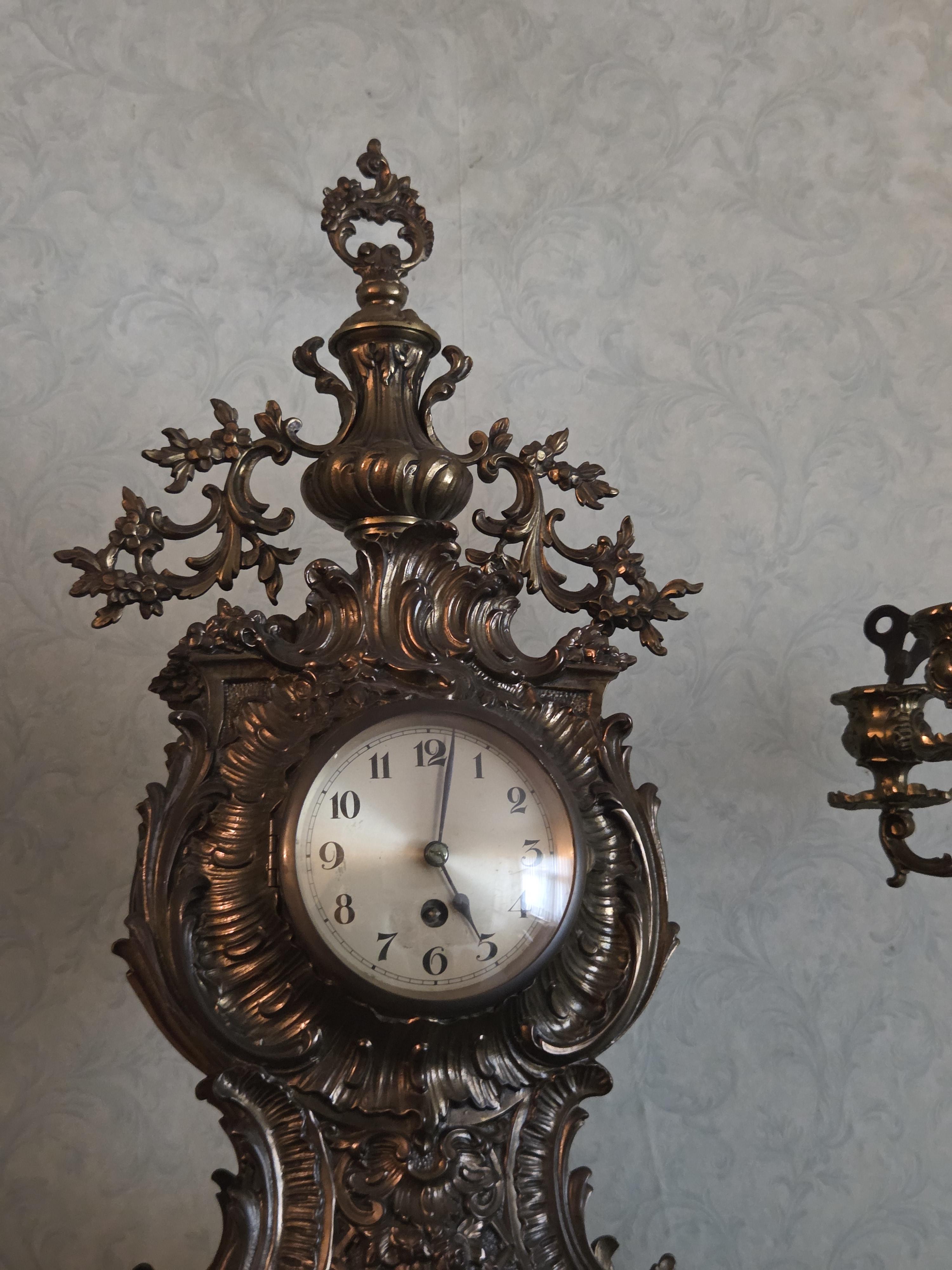 Driedelig schouwgarnituur bestaande uit een rijkelijk gedecoreerde tafelklok met Romeinse cijfers en twee bijbehorende 5-armige kandelaren lot 57 – foto 3 – kavel bij Goeiendeal, J