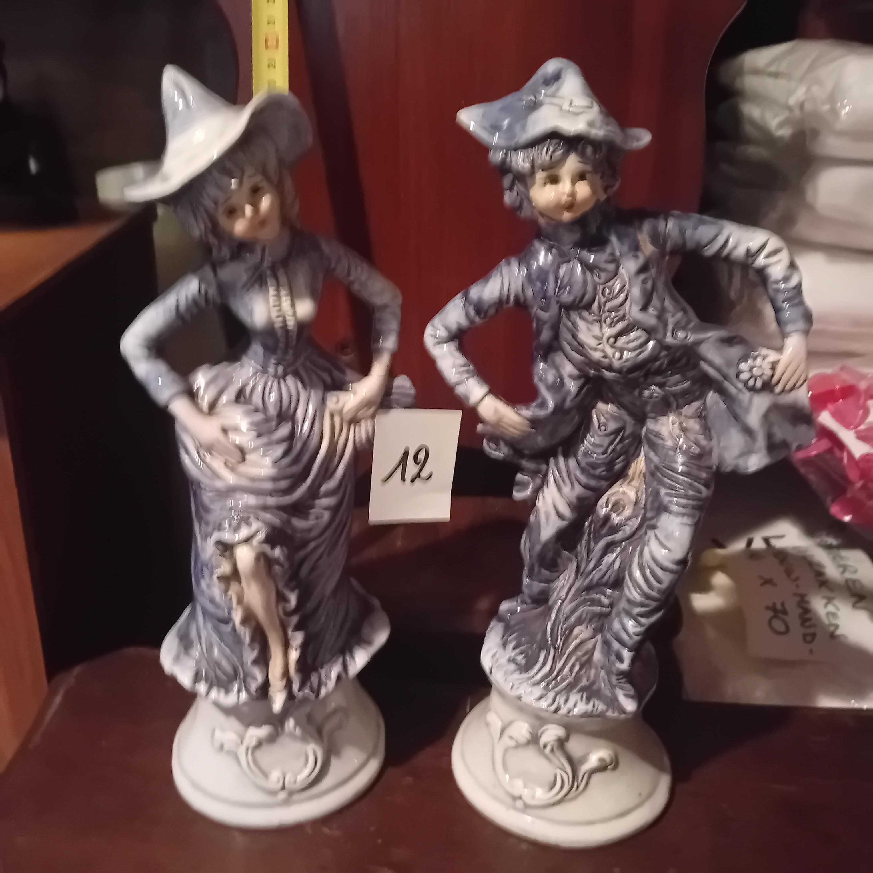 Set van 2 porseleinen karakterbeeldjes van een zittende vrouw en man in blauw-witte klederdracht lot 12 – kavel bij Goeiendeal, Lommel