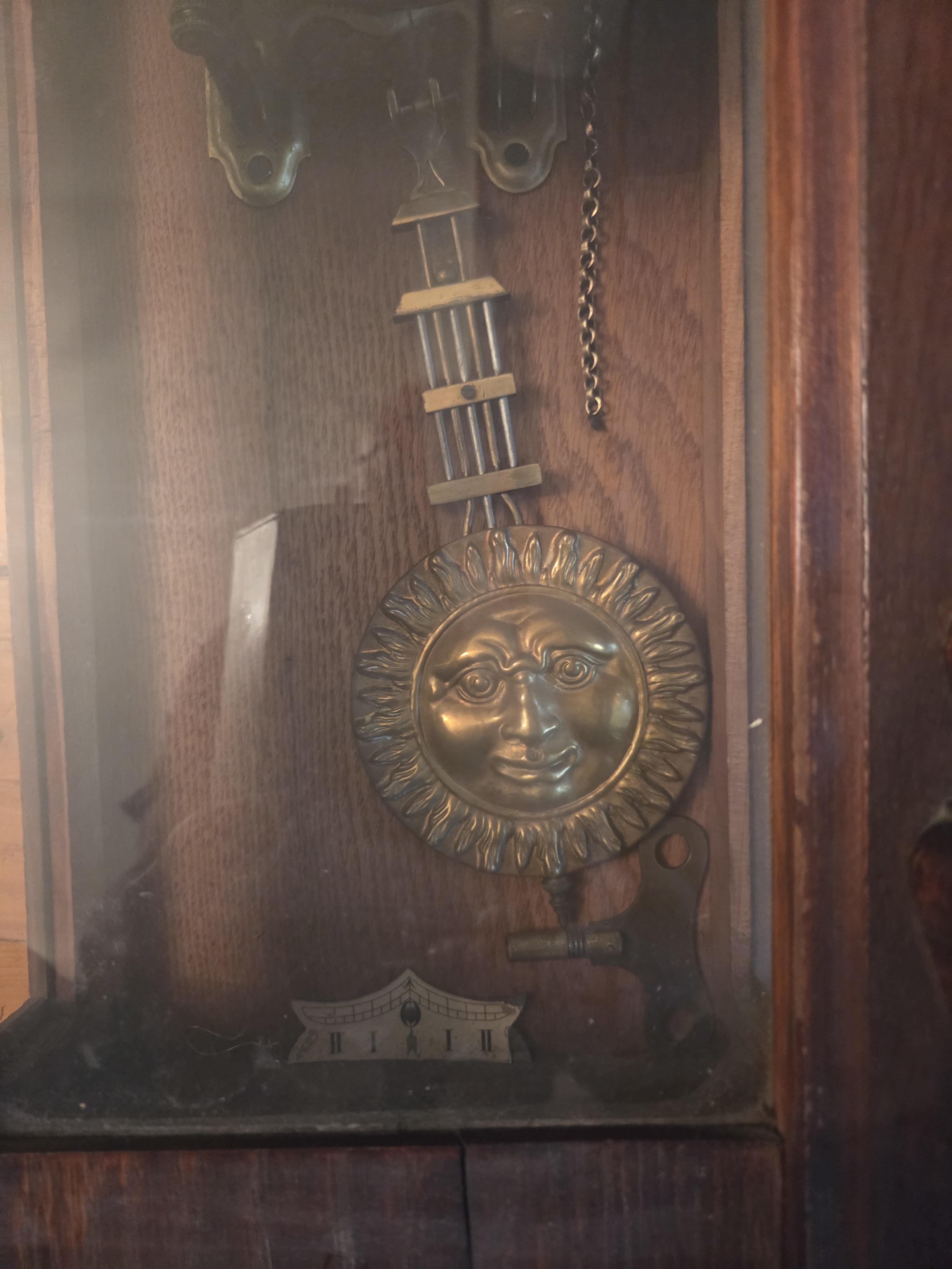 Klassieke regulateur wandklok met versierde kast en slinger met zonsgezicht – Lot 95 – foto 2 – kavel bij Goeiendeal, Jette