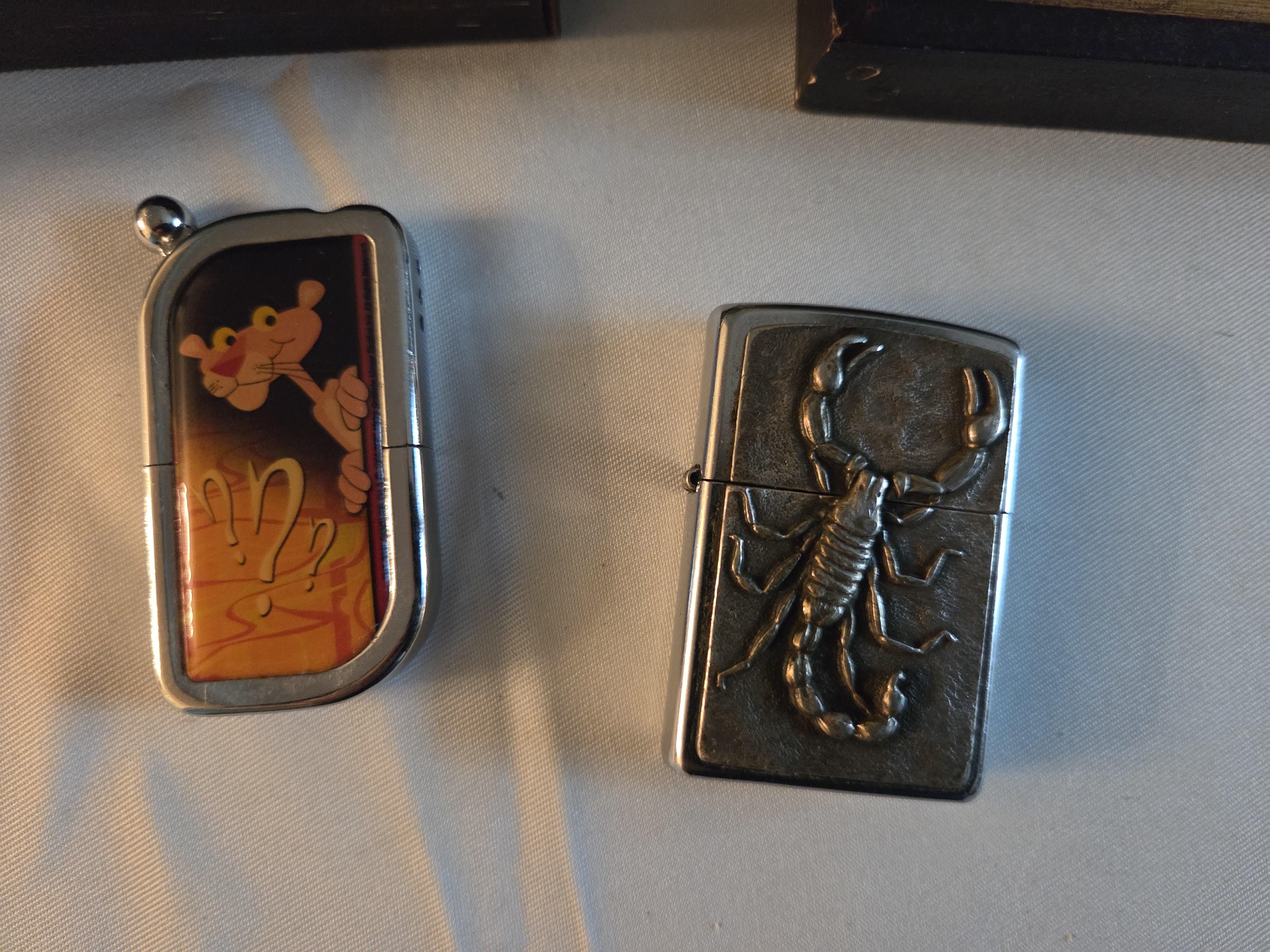 Set bestaande uit twee kleine schilderijtjes in goudkleurige lijsten (tavernescène en molen aan het water) en twee Aanstekers – Lot 124 – foto 2 – kavel bij Goeiendeal, Jette