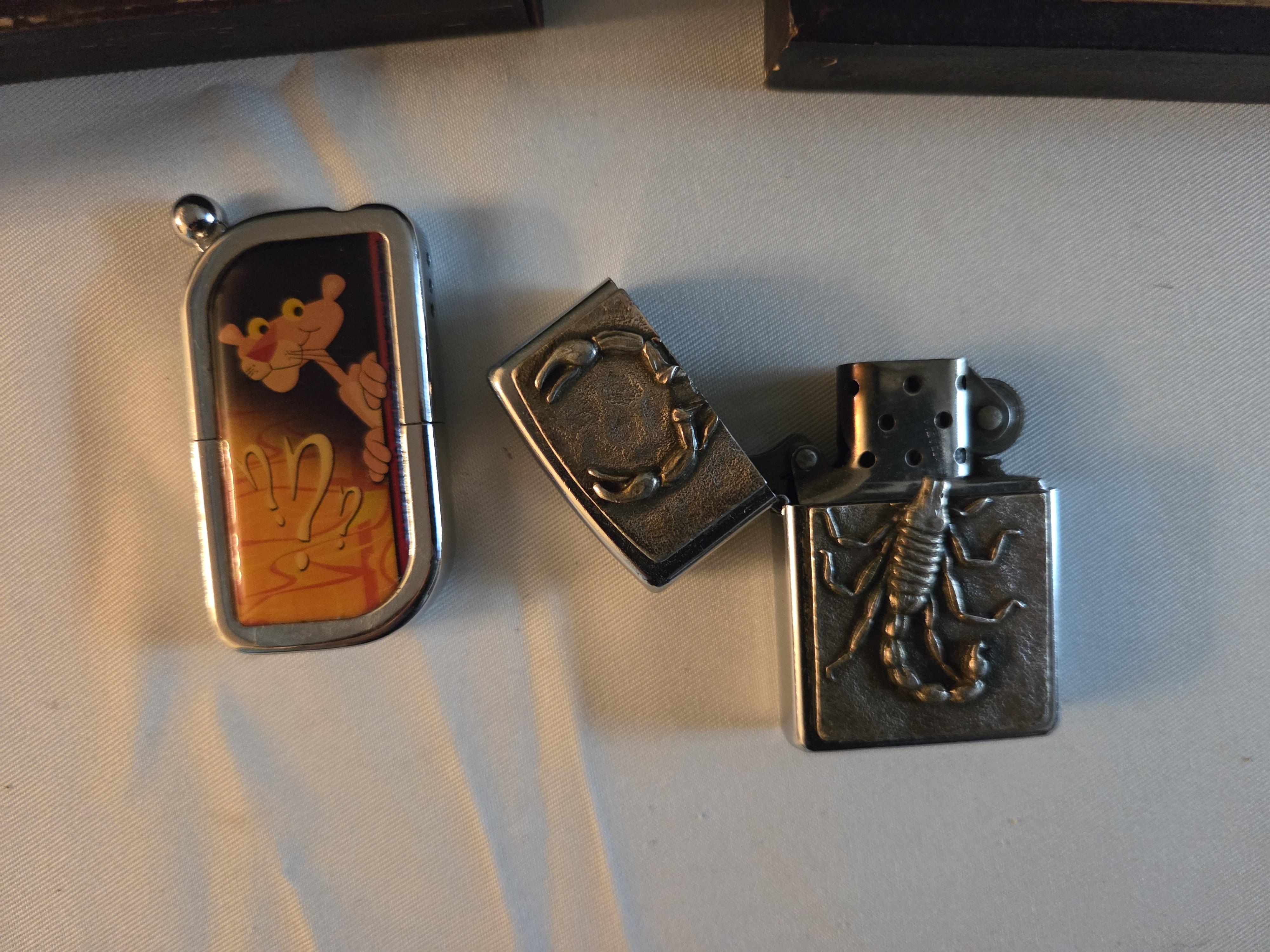Set bestaande uit twee kleine schilderijtjes in goudkleurige lijsten (tavernescène en molen aan het water) en twee Aanstekers – Lot 124 – foto 3 – kavel bij Goeiendeal, Jette
