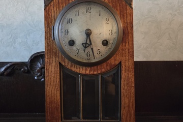 Afbeelding van Klassieke schouwklok met een rechthoekige houten kast, ronde wijzerplaat en glas-in-lood venster onderaan – Lot 101