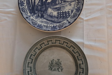 Afbeelding van Set van twee wandborden: een Delfts blauw bord met molenlandschap en een bord met Grieks sleutelmotief en centrale amfora – Lot 123