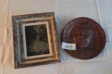 Afbeelding van Set bestaande uit een klein ingelijst schilderij van een figuur bij het water en een rond reliëfportret van een kind – Lot 113