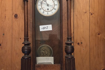 Afbeelding van Regulateur wandklok met een gedecoreerde houten kast en een slinger voorzien van een reliëf – Lot 102