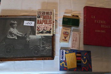 Afbeelding van Set met diverse verzamelobjecten, waaronder een ingelijste zwart-wit foto van een kind in een trapauto, boeken zoals La Patrie Belge en kleurpotloden – Lot 169
