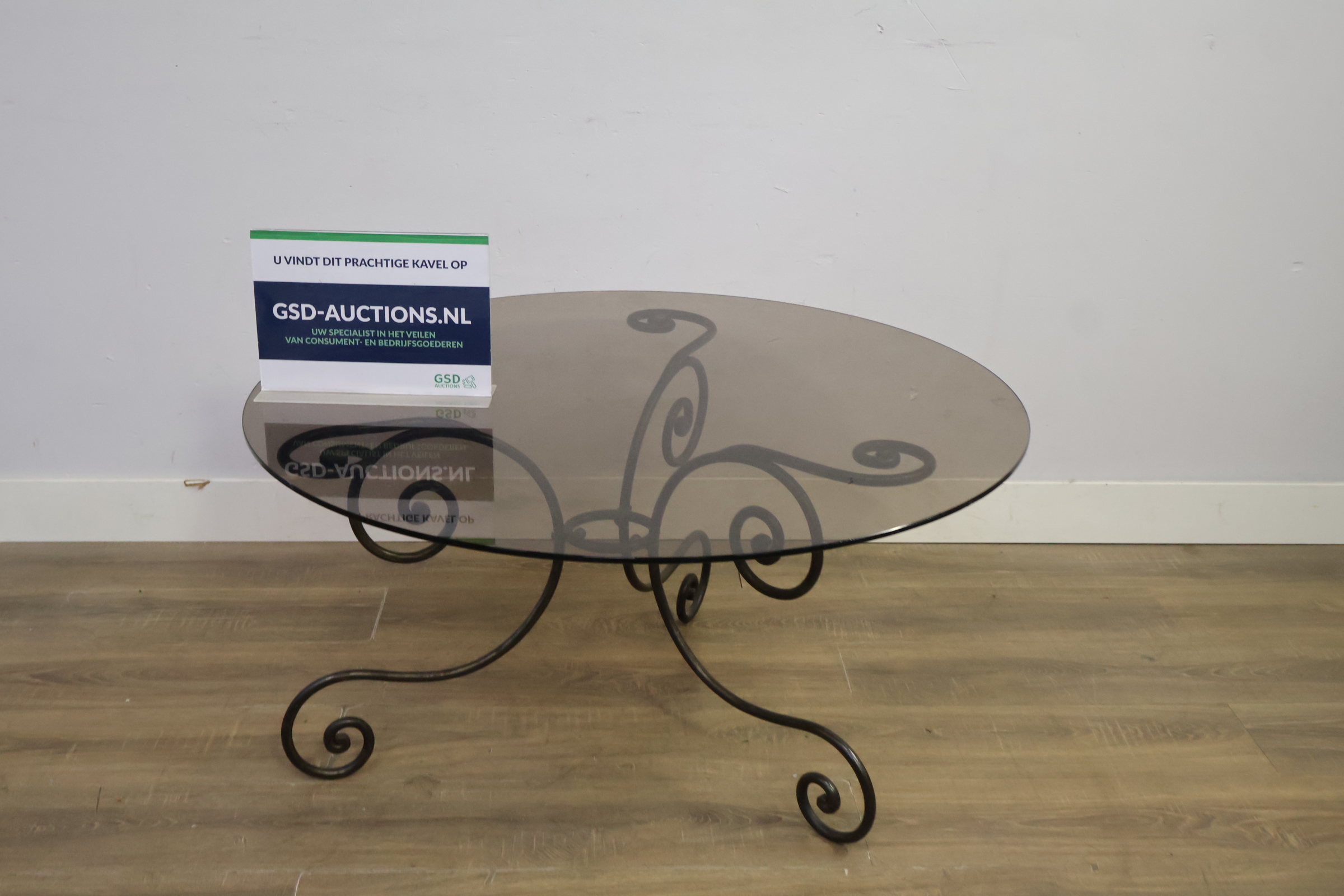 Ronde tafel met glazen blad en smeedijzeren onderstel – foto 2 – kavel bij GSD Auctions, Zoeterwoude