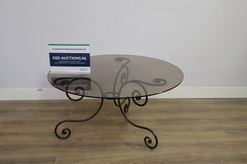 Afbeelding van Ronde tafel met glazen blad en smeedijzeren onderstel