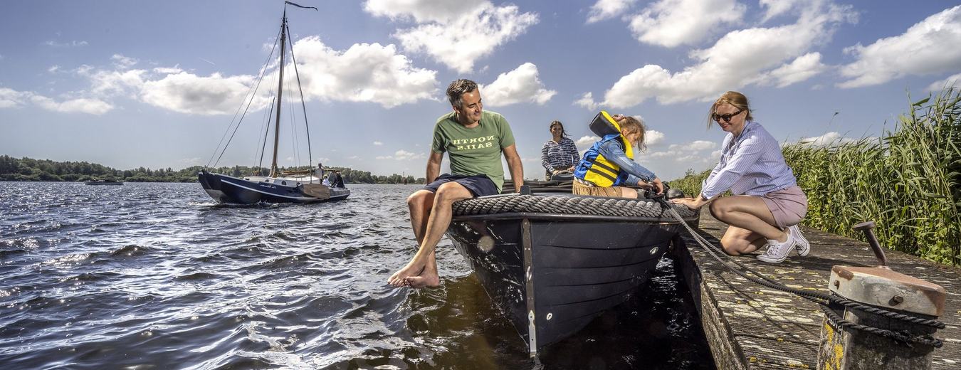 Gezin met een sloep aan de steiger