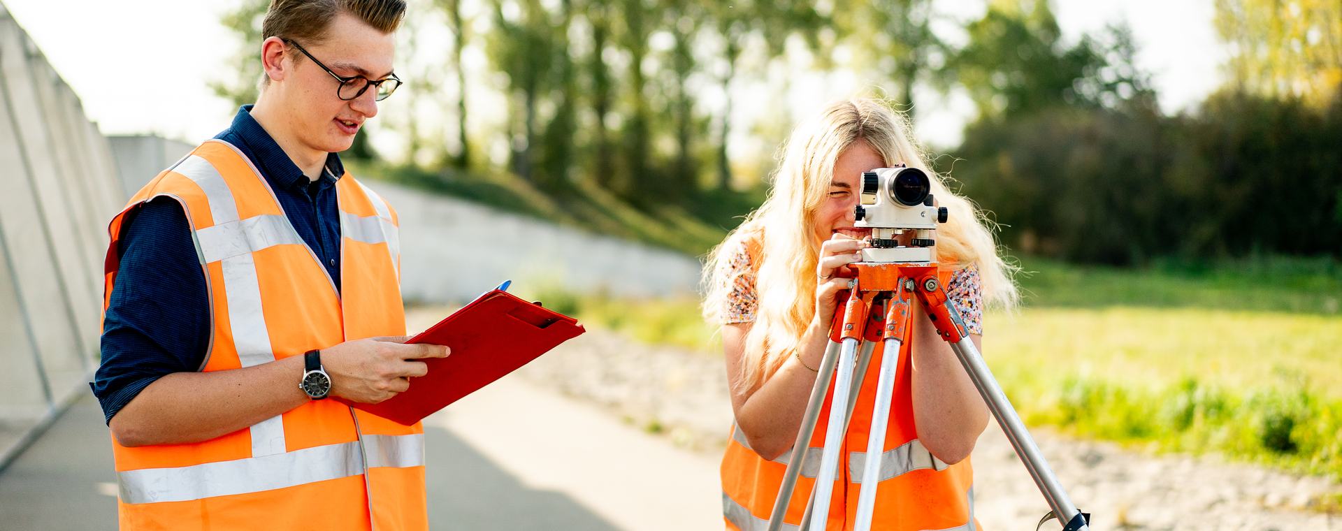 Twee studenten Land- en Watermanagement bezig met landmetingen