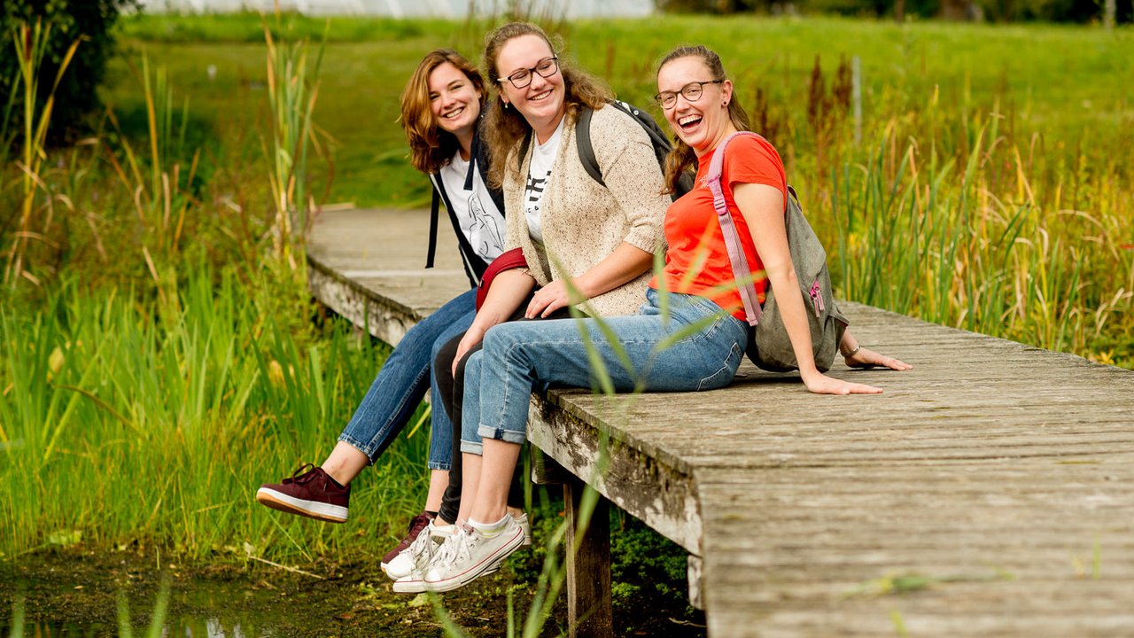 Studenten HVHL zitten op de brug van landgoed Larenstein