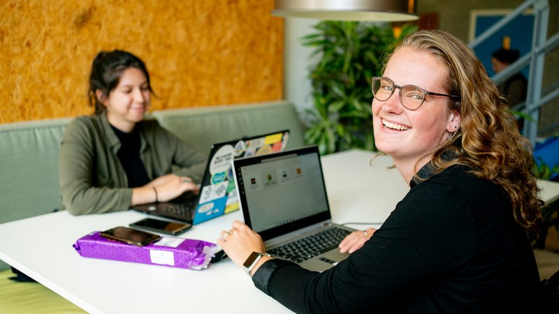 Student zit achter laptop in studieruimte