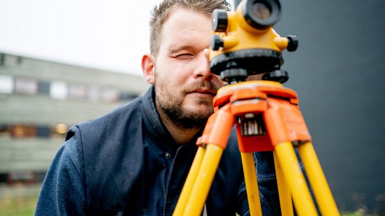 Een cursist die landmetingen aan het doen is