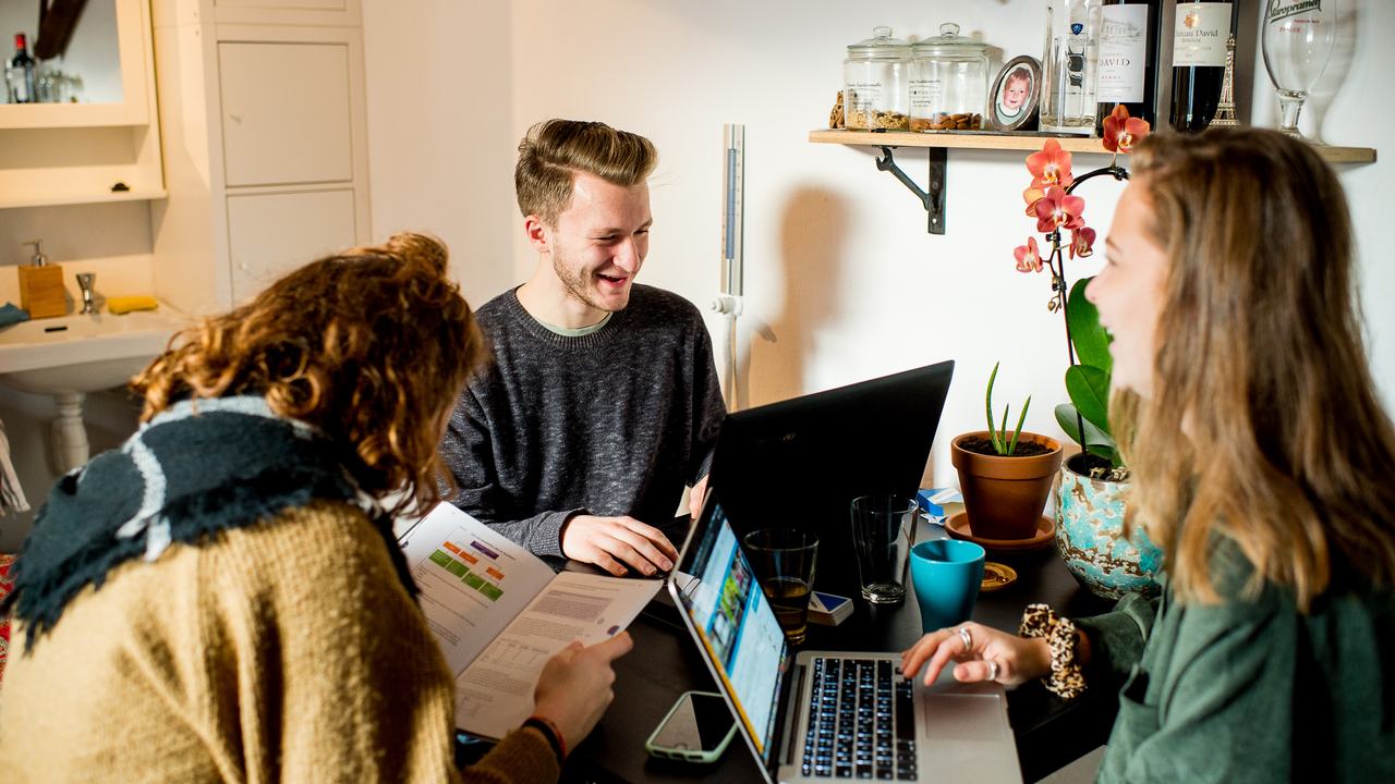 HVHL studenten met laptops op tafel in studentenkamer