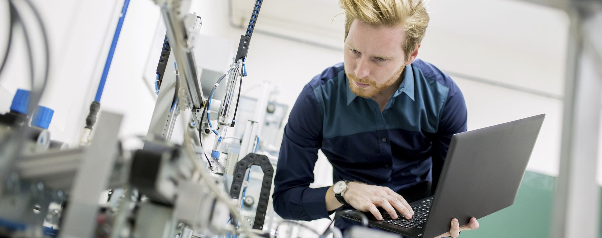 Student met laptop optimaliseert het proces in een fabriek