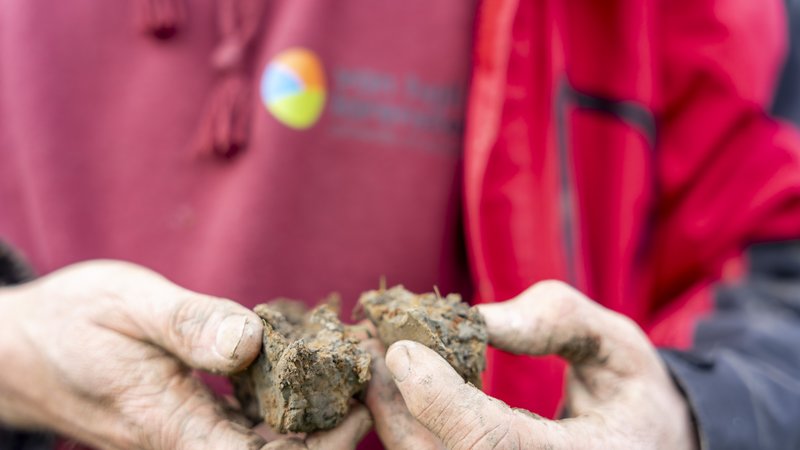 Onderzoeker laat een bodemmonster zien