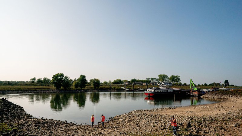 Studenten verrichten metingen langs een rivier
