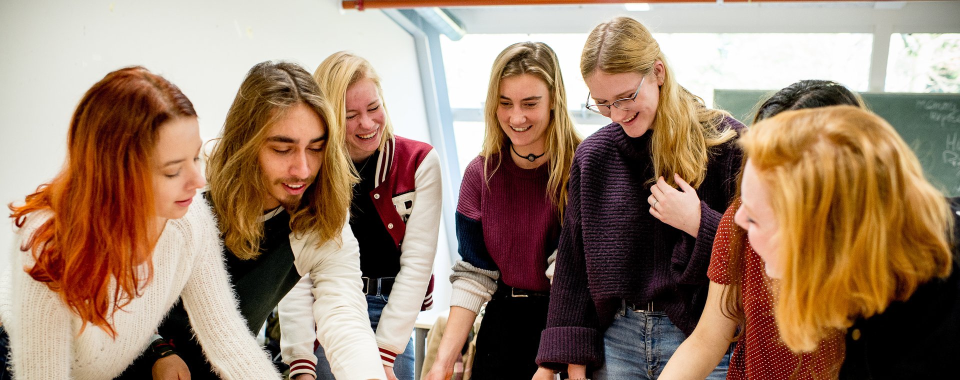 Studenten HVHL staan om tafel en brainstormen met papier en post-its