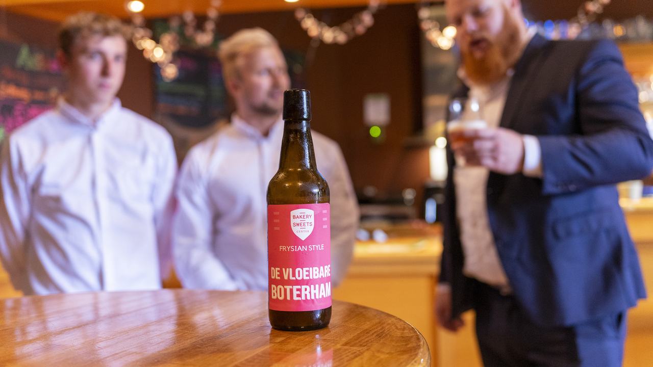 Op de voorgrond het "vloeibare boterham" biertje met daarachter studenten en Aant Jelle Soepboer