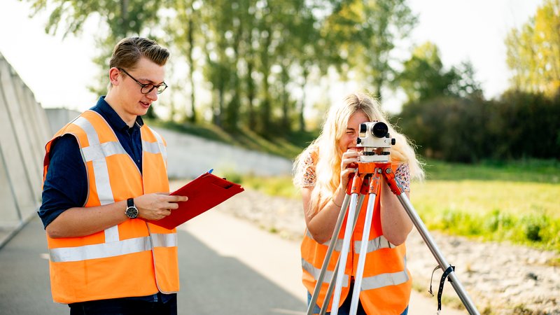 Twee studenten Land- en Watermanagement bezig met landmetingen