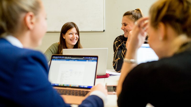Groepje studenten Equine Sports and Business werken aan een project met laptop op tafel