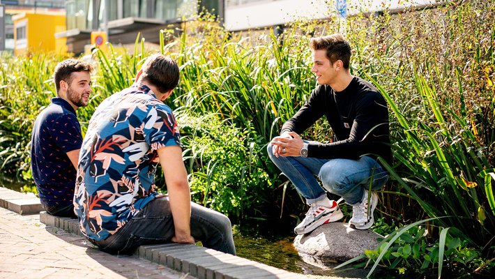 Studenten op stoep in groene leefomgeving voor het project Groenblauwe Stad