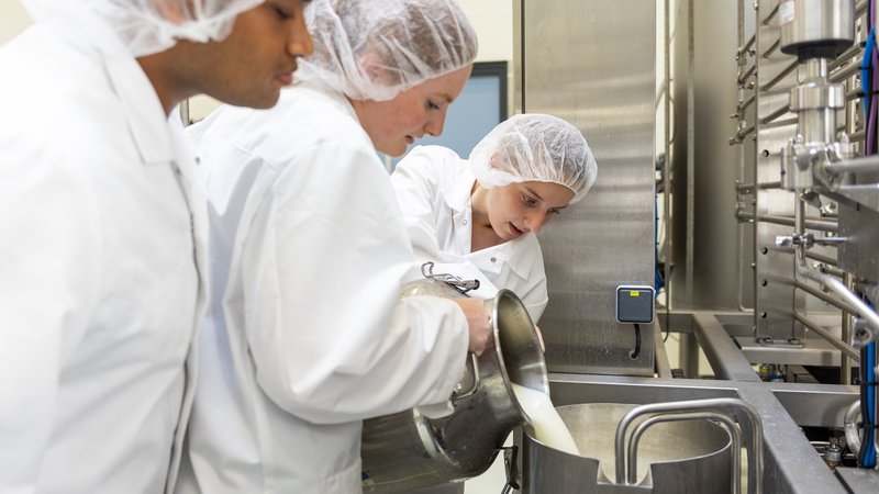 Studenten gieten melk in de digicooker in het FACT