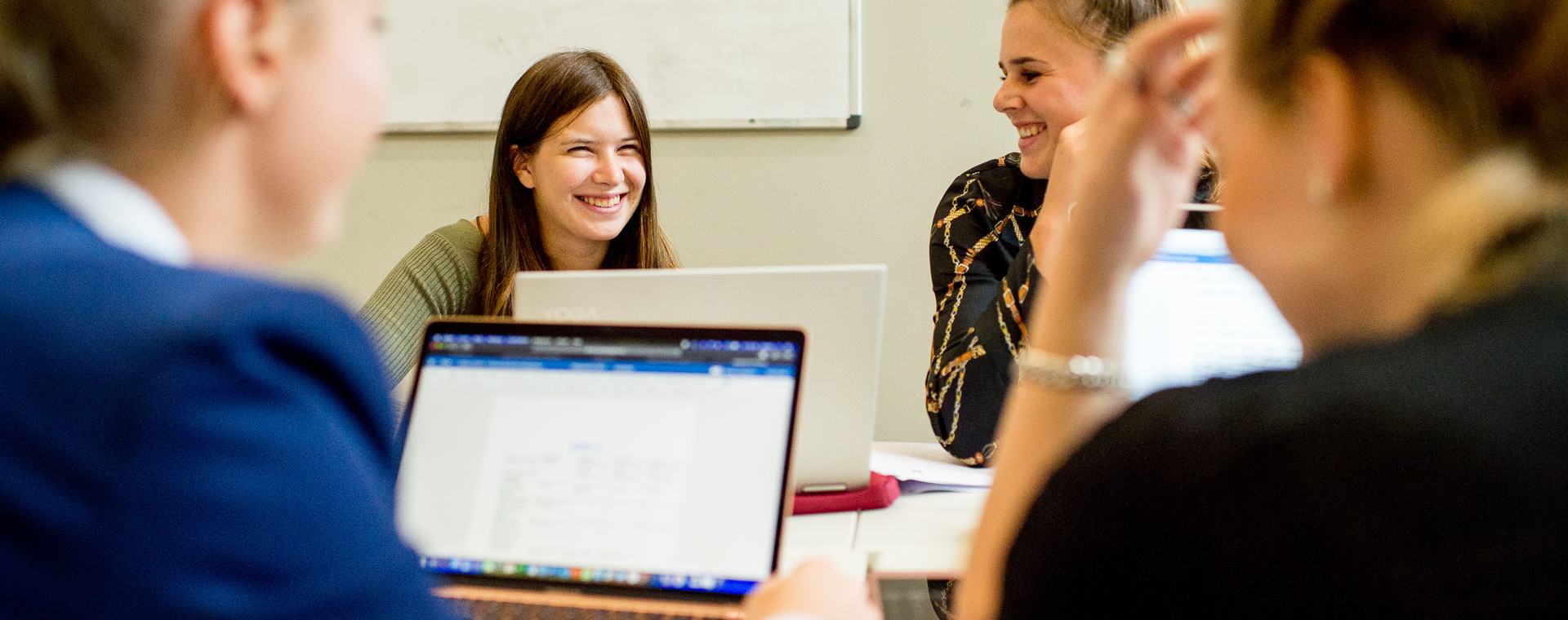 Groepje studenten Equine Sports and Business werken aan een project met laptop op tafel