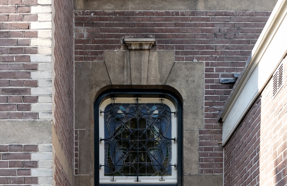 Ingang met zandstenenomlijsting met bovenlicht met glas-in-lood decoratie - 2016