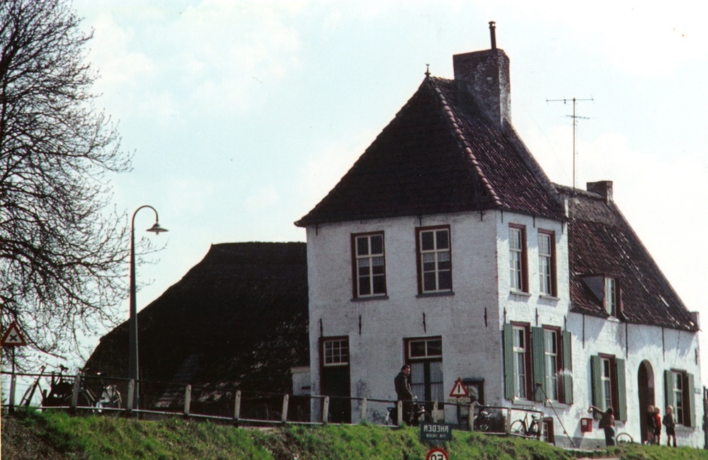 Kleurenfoto van het veerhuis met personen ervoor