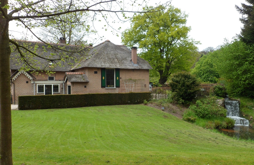 Zijkant woning met waterval van oude molen