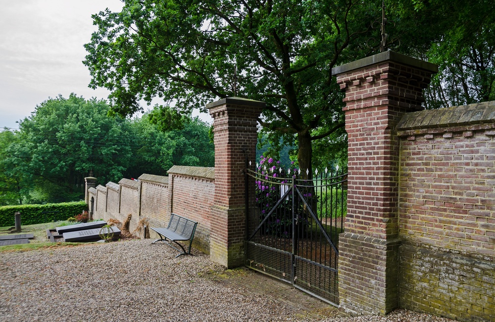 Muur met smeedijzeren hekwerk rondom de begraafplaats - 2016