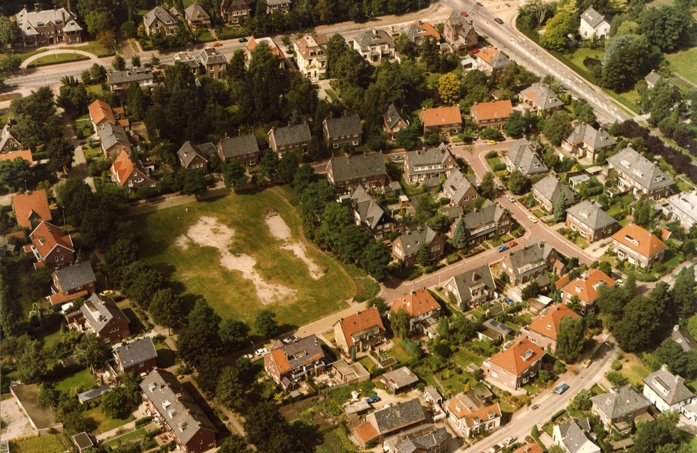 Luchtfoto plein met met kaalgetrapt grasveld