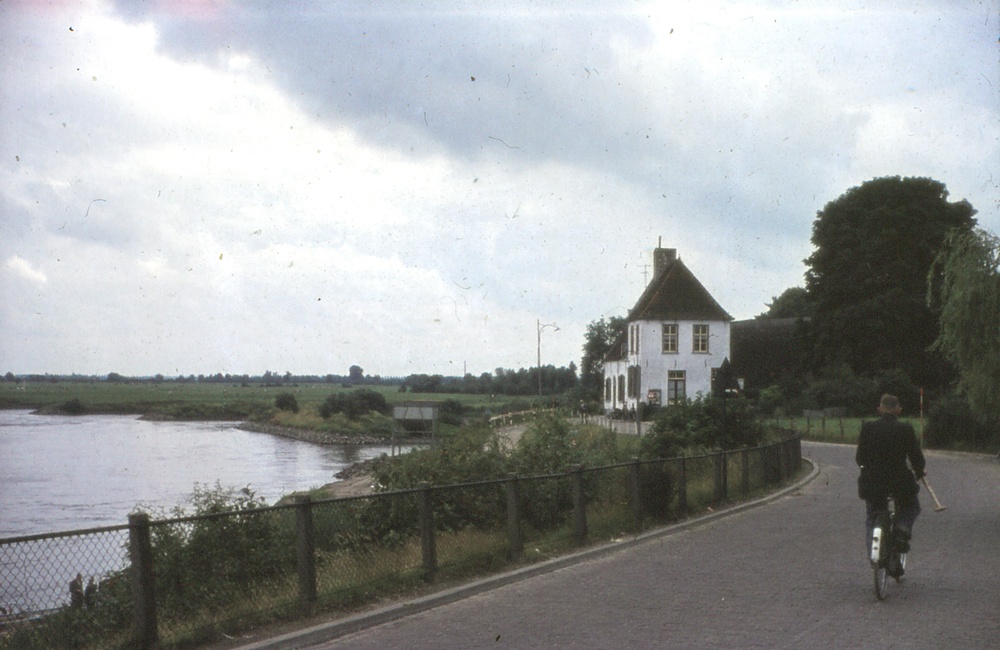 Man op fiets richting veerhuis vanaf De Steeg