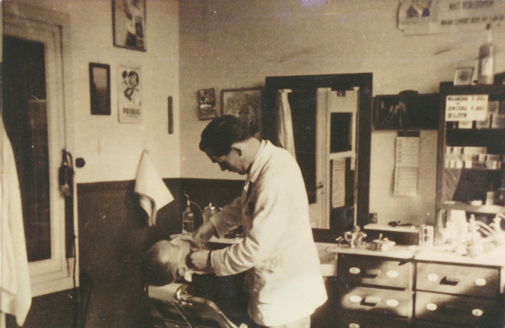 Kapper Gerrit Beijer scheert een klant "nat"(Spoorstraat 29) - ca. 1940