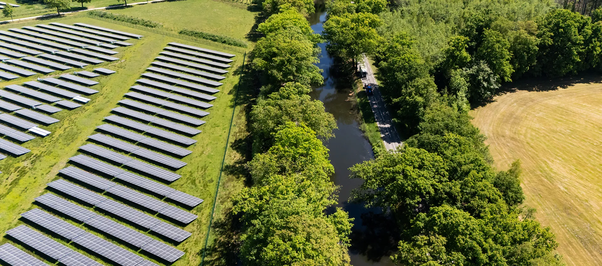 Zonnepanelen op een veld naast een watergang